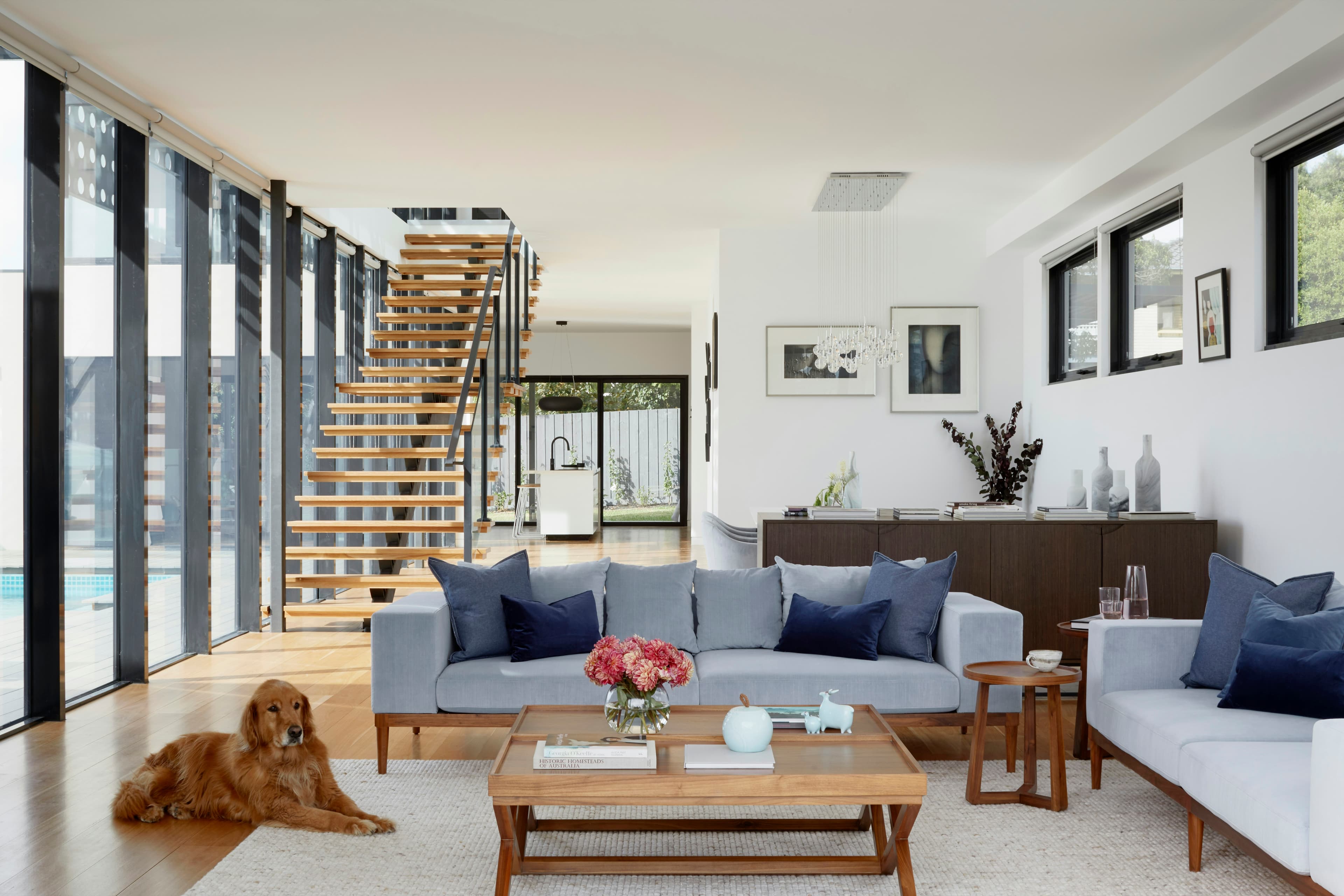 Bright family living room with sofas and an open staircase