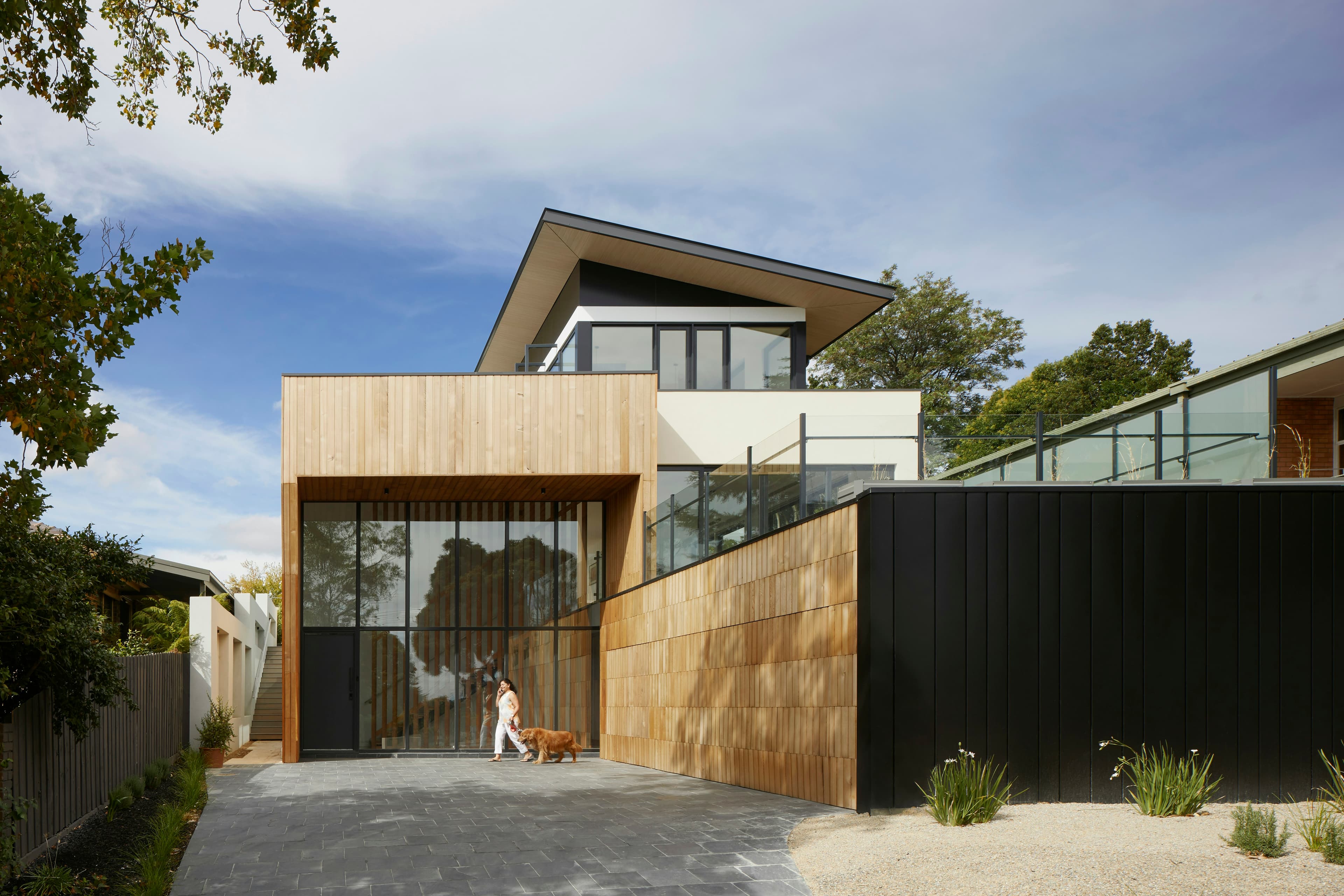 Substantial two-storey home with timber cladding and a private driveway